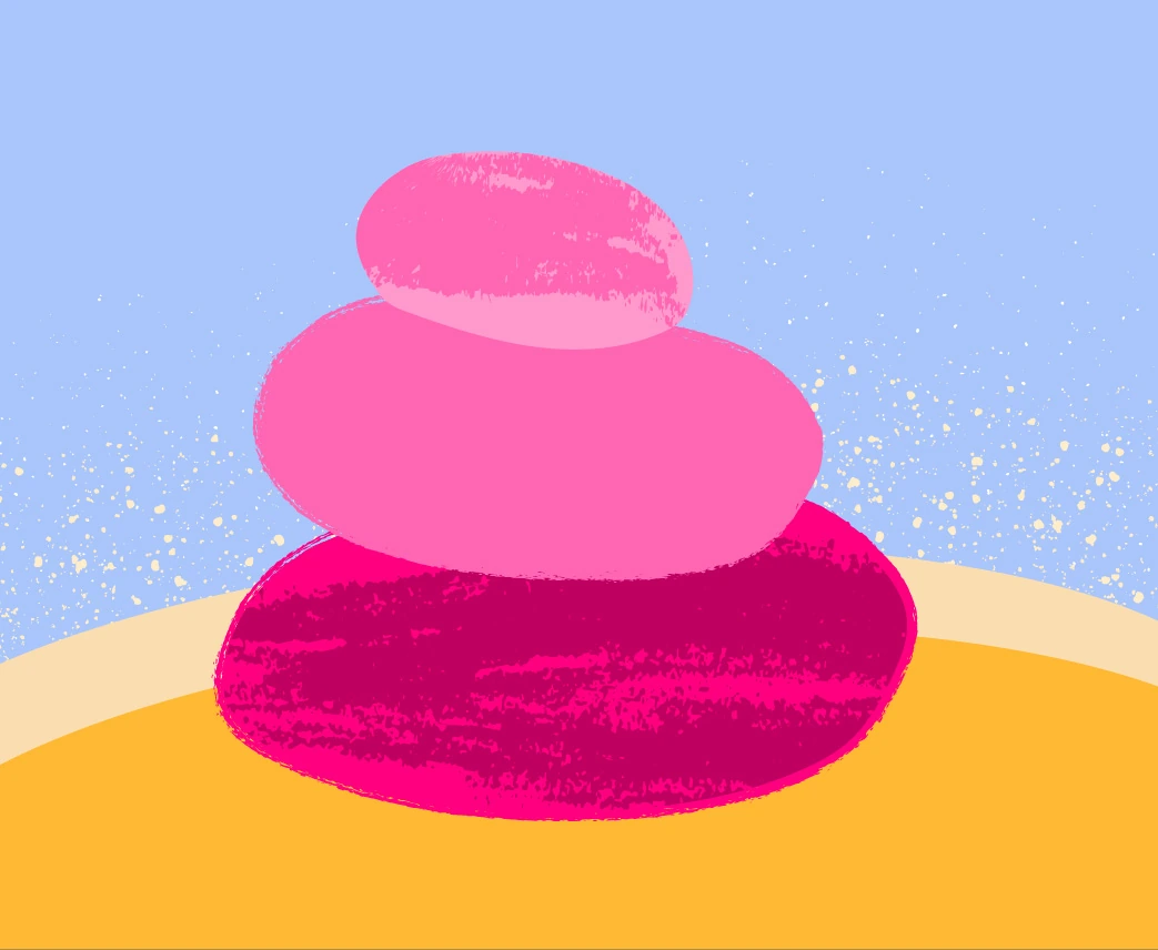 Textured pink balancing stones against a blue sky